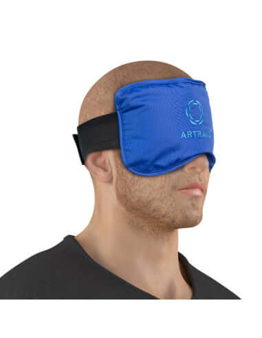 ARTRAID miego kaukės naudojimo pavyzdys, vyras dėvi mėlyną akių kaukę skirtą poilsiui ir šviesos blokavimui miego metu.